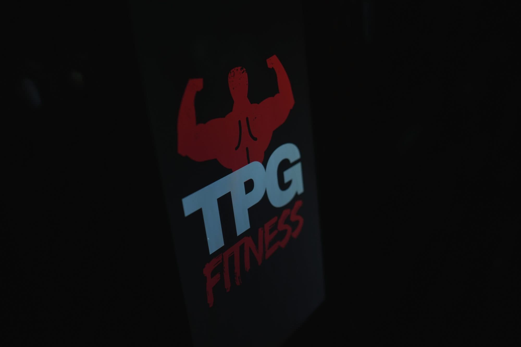 Close-up of the TPG Fitness logo panel on the kiosk enclosure