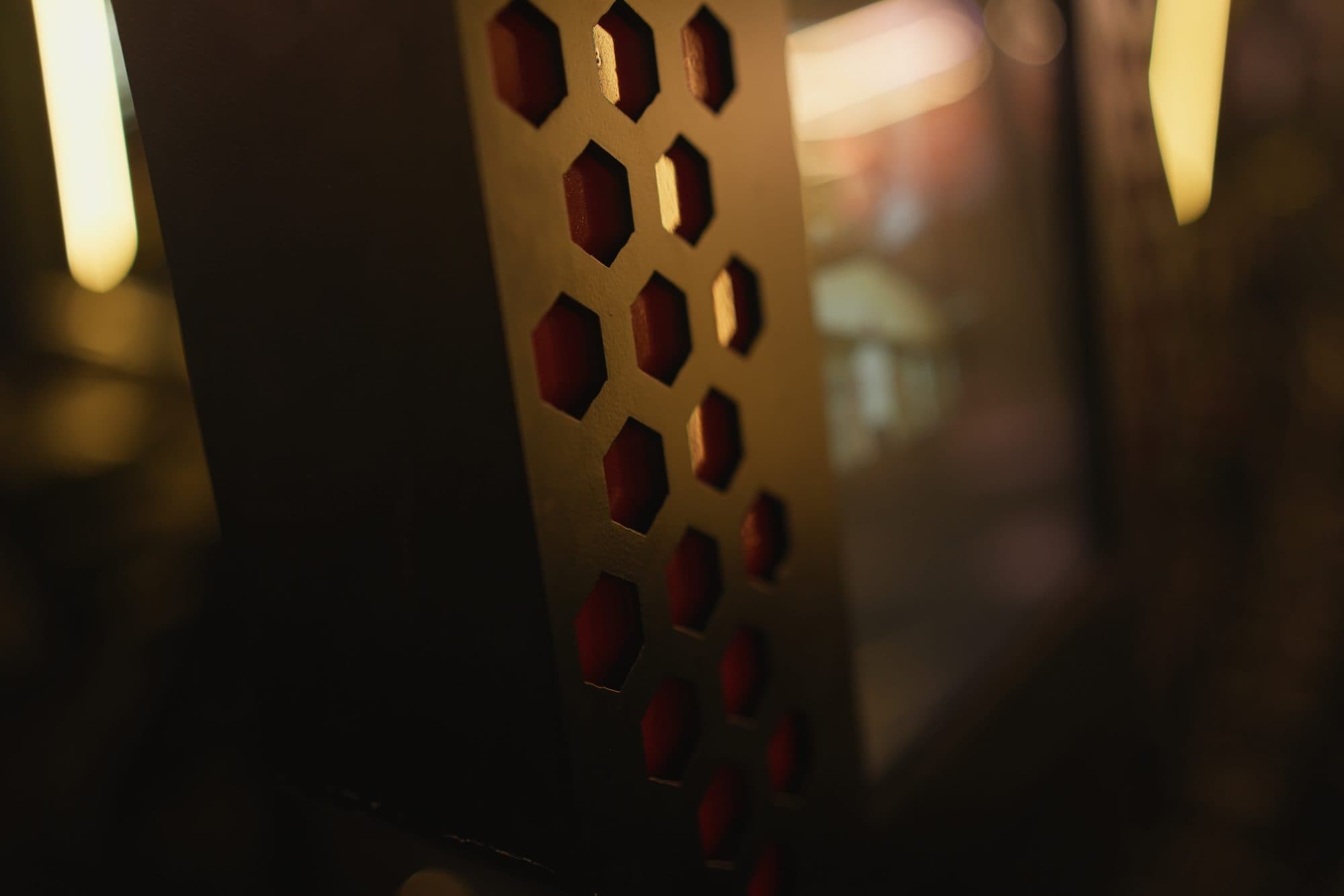 Macro detail of the kiosk's glowing red hexagonal vent panel