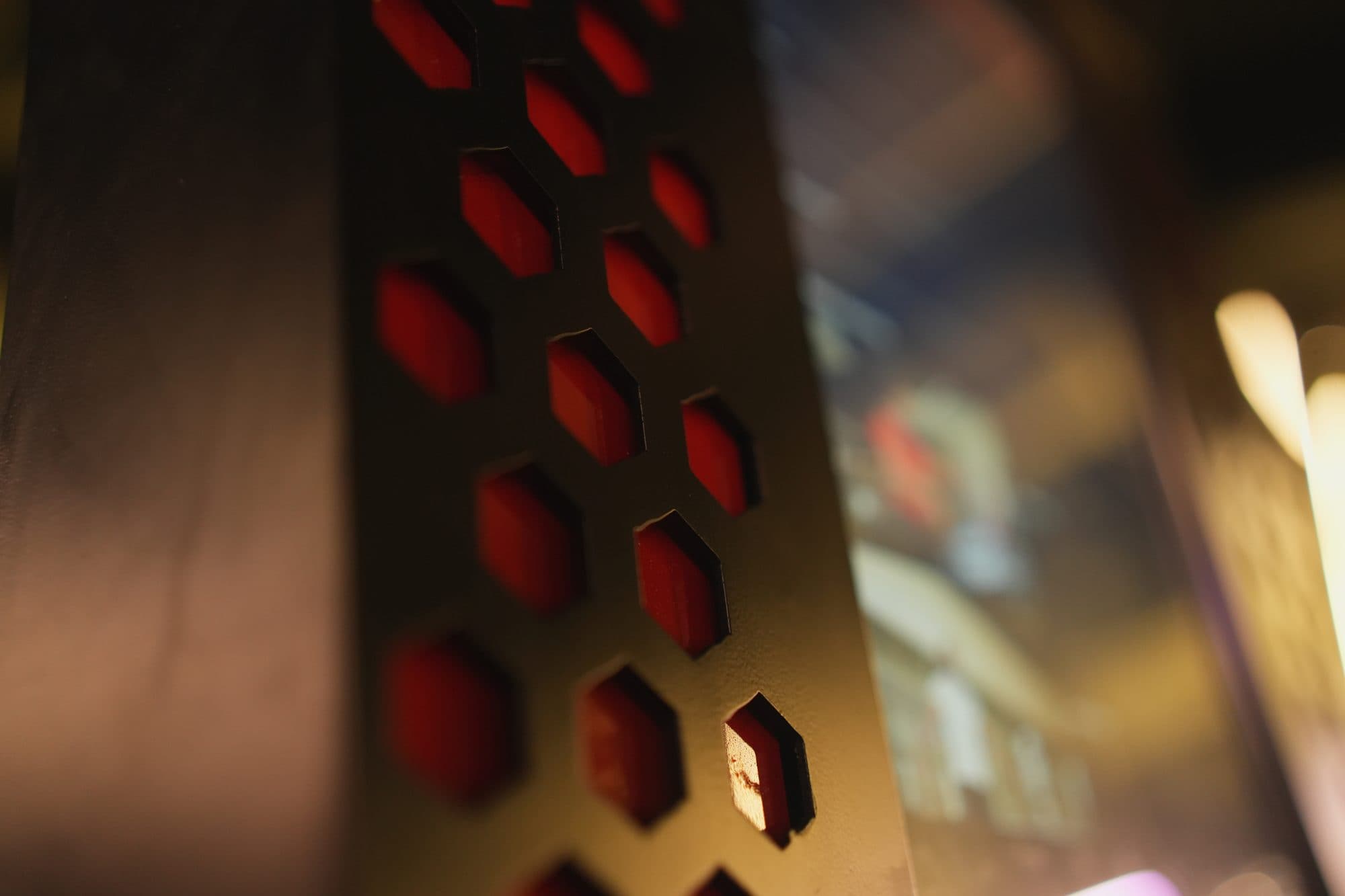 Macro of the hex vent panel with a single cell lit brighter than the rest