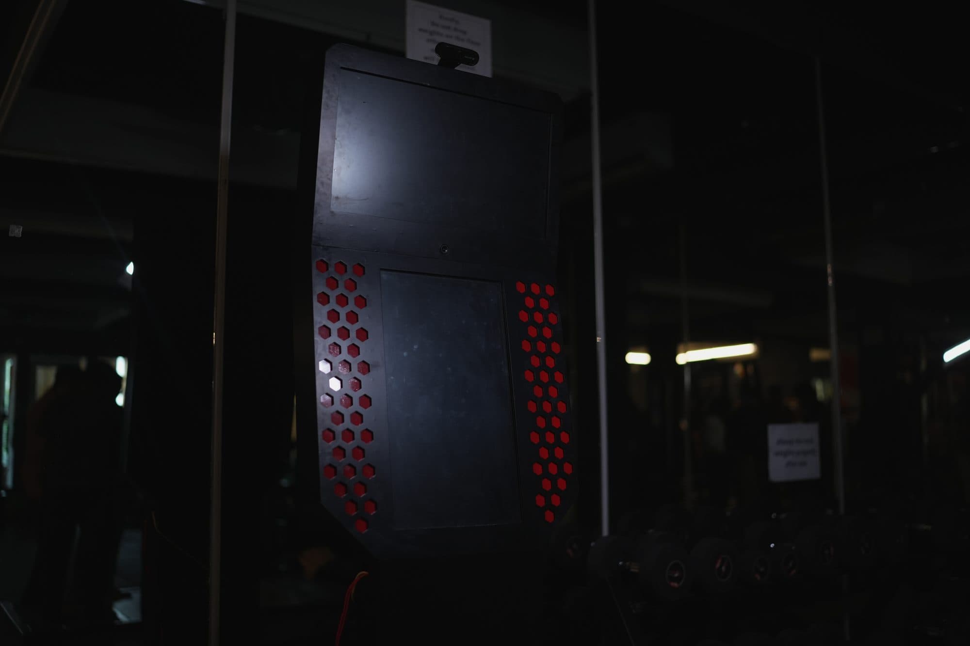 Wide low-light shot of the kiosk on the gym floor with a lens flare