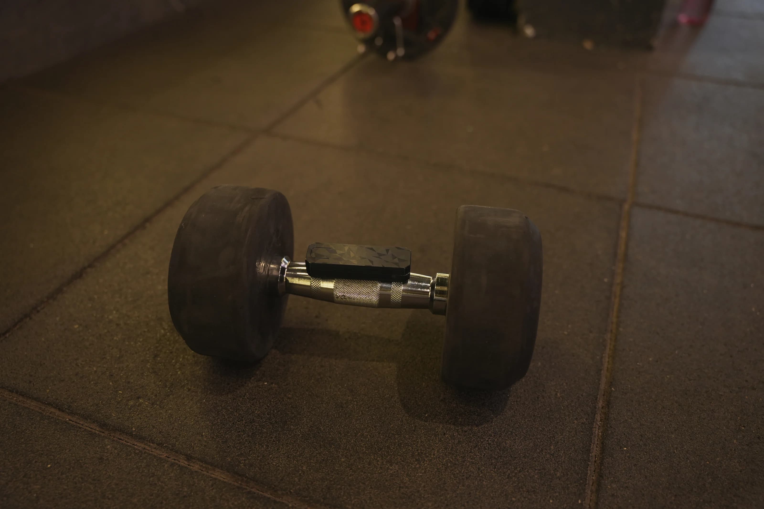A dumbbell on a gym floor, where the T_Block prototype is tested